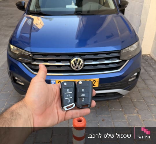 מפתחי רכב מול רכב כחול בחניה